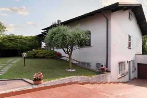 VertemateFLOWERS ROOM stanza privata tra Como e Milano的院子里有树的白色房子