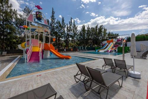 库萨达斯Ramada Hotel & Suites by Wyndham Kusadasi的一个带滑梯的游乐场的游泳池