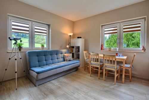 下乌斯奇基Domek Limba的客厅配有蓝色的沙发和桌子