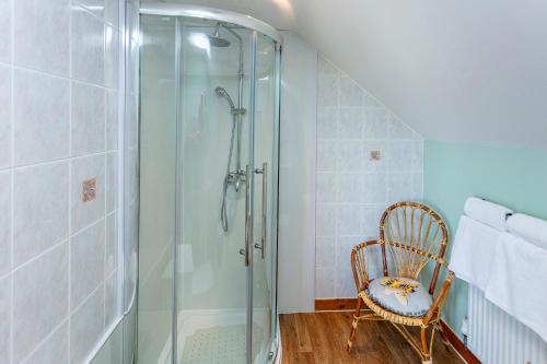 阿勒浦Lochbroom Lodge的带淋浴的浴室,配有椅子和玻璃淋浴间