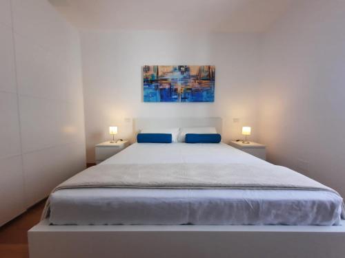 切萨雷奥港Kennedy Apartments- Porto Cesareo的白色卧室配有一张带两盏灯的大床