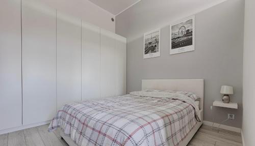 罗兹Ekskluzywny Loft Tymienieckiego的白色卧室配有一张带铺着地毯的床
