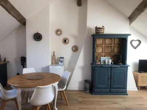奥尔良Le Domremy F2 au cœur d'Orléans的一间设有蓝色橱柜和桌椅的用餐室