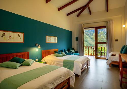 CocachimbaGocta Andes Lodge的一间卧室设有两张床和大窗户