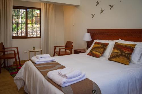 库斯科Inkantari Boutique Hotel的一间卧室配有一张大床和毛巾