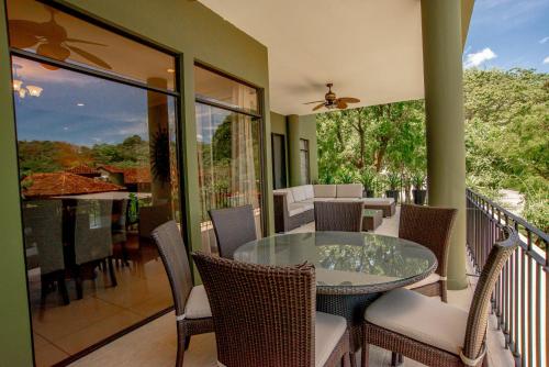 普拉卡海尔Carao T5-2 Luxury Apartment Adults Only - Reserva Conchal的阳台配有玻璃桌和椅子
