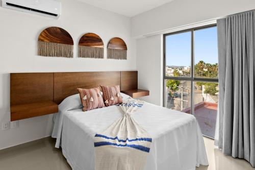 马萨特兰Casa Barros Vacation Condos的一间卧室设有一张床和一个大窗户