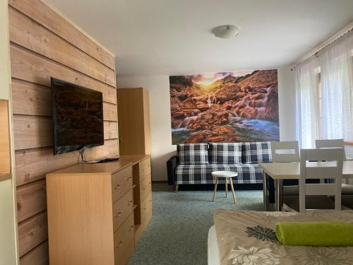 哈拉霍夫司马膳食公寓的客厅设有床铺和墙上的电视