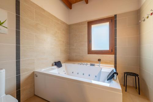 坎波斯Finca Es Figueral的一间带白色浴缸和窗户的浴室
