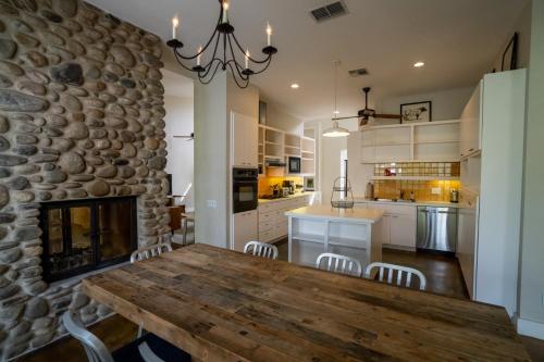 凯尔Sage Hill Inn & Spa的厨房配有木桌和石墙