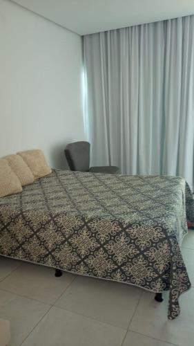 加拉尼温斯Casa Duplex - Garanhuns的一间卧室配有一张带图案毯子的床