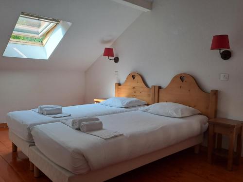 吕格兰Duplex dans Chalet entre Lac et Montagne - Vue Lac的卧室内的一对床,卧室设有窗户