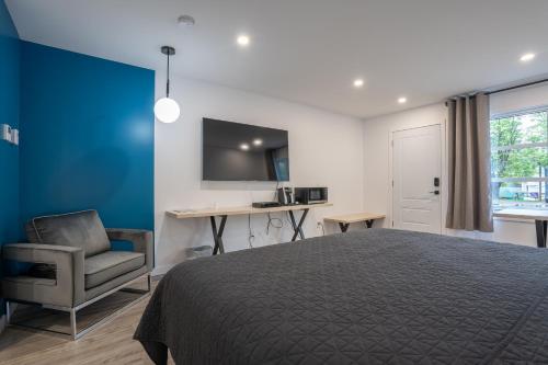 拉马巴耶Le 2020 Charlevoix的一间卧室配有一张床、一把椅子和一张书桌