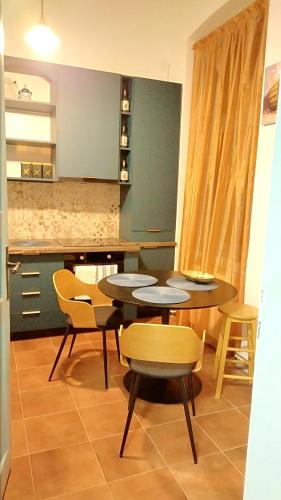 蒂米什瓦拉Melina Studio的一间带2张桌子和椅子的用餐室以及一间厨房