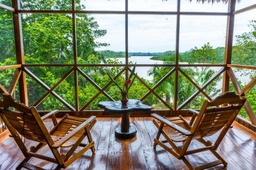 马尔多纳多港Sotupa Eco Lodge的带窗户的客房内配有两把椅子和一张桌子