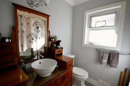 温哥华The Orange Door Bungalow的一间带水槽和卫生间的浴室以及窗户。