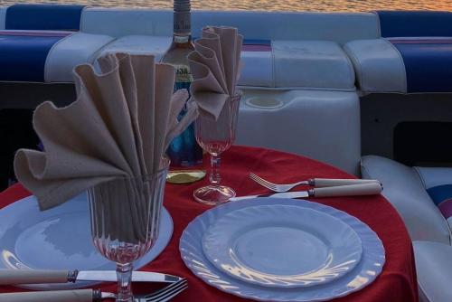 法鲁GuestBoat Milagre的一张桌子,上面放有盘子和两杯酒杯