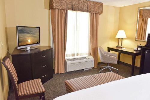 亚历山德里亚亚历山德里亚希尔顿恒庭旅馆&套房酒店的酒店客房带一张床、一台电视和椅子