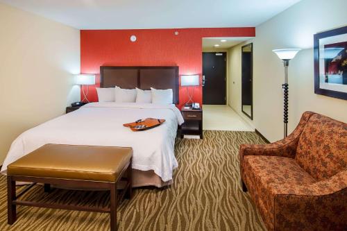 奥古斯塔Hampton Inn by Hilton Augusta Fort Eisenhower的配有一张床和一把椅子的酒店客房