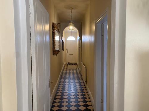 伯明翰Albany house的一条长长的走廊,铺有蓝色和白色的格子地板