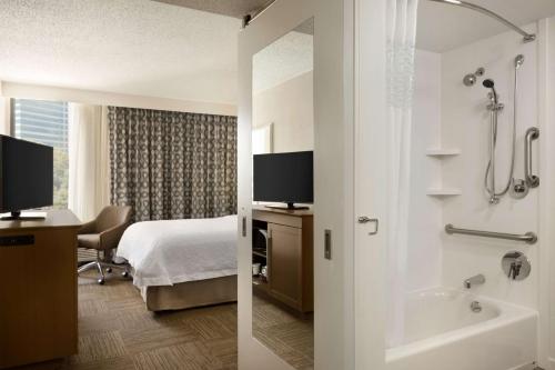 亚特兰大亚特兰大-巴克海特汉普顿酒店的酒店客房设有一张床和一间带浴缸的浴室。