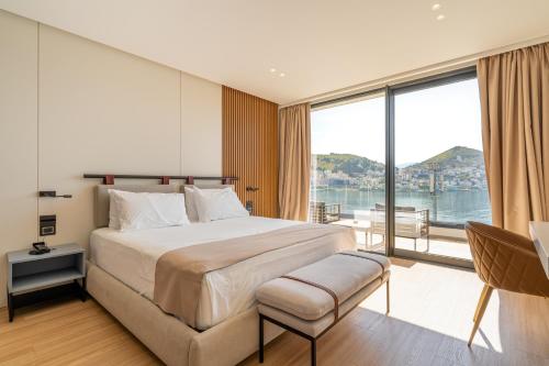 萨兰达Yacht Premium Hotel的一间卧室设有一张大床和一个大窗户