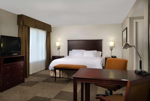 阿尔特斯阿尔图斯希尔顿恒庭旅馆&套房酒店的配有一张床和一张书桌的酒店客房