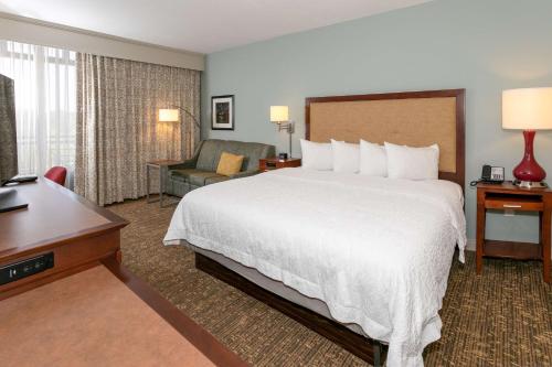 纳什维尔纳什维尔青山汉普顿酒店及套房的酒店客房设有一张大床和一张书桌。
