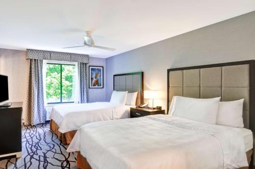 阿灵顿Homewood Suites by Hilton Boston Cambridge-Arlington, MA的酒店客房设有两张床和窗户。