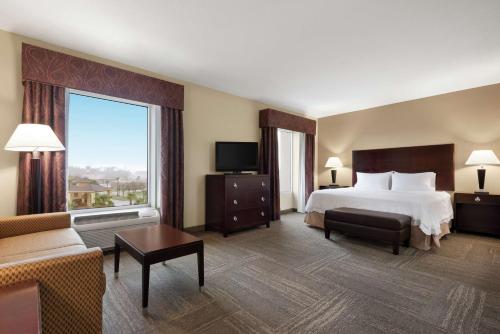 布伦瑞克布伦瑞克汉普顿套房酒店的酒店客房设有一张床和一个大窗户