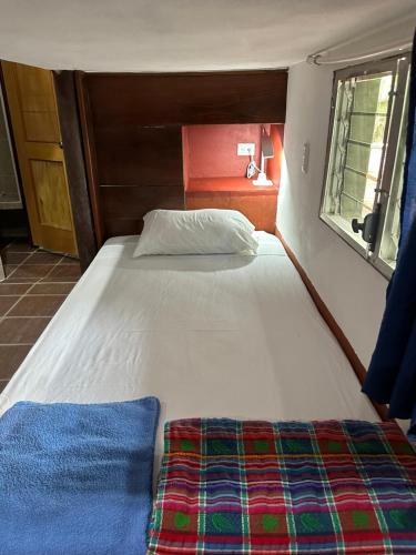 弗洛勒斯Out Back Zapote的窗户客房内的一张大白色床