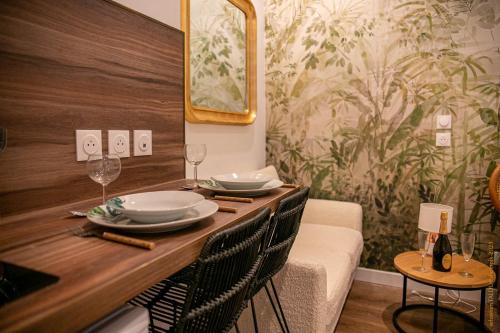 鲁昂CosyRouen Bali Spa Hamman的用餐室配有带盘子和酒杯的桌子