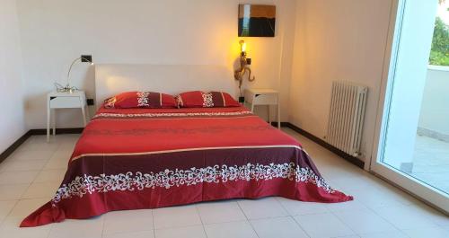 里乔内Villetta Panoramica con Giardino a Riccione的一间卧室配有红色的床和两个红色枕头