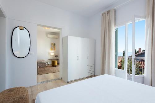 巴尔巴蒂Reana Elegant Apartments的白色的卧室设有床和大窗户