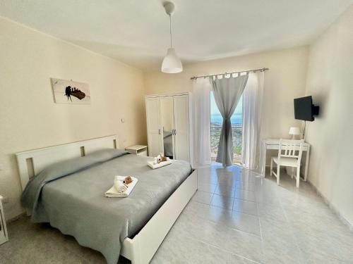 福尔米亚Il Nido delle Rondini的一间卧室配有一张床、一张书桌和一个窗户。