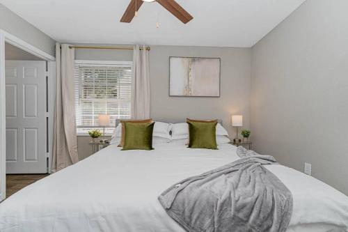 格林斯伯勒King Beds 2- Smart TVs-Free Parking-Patio的卧室配有带绿色枕头的大型白色床