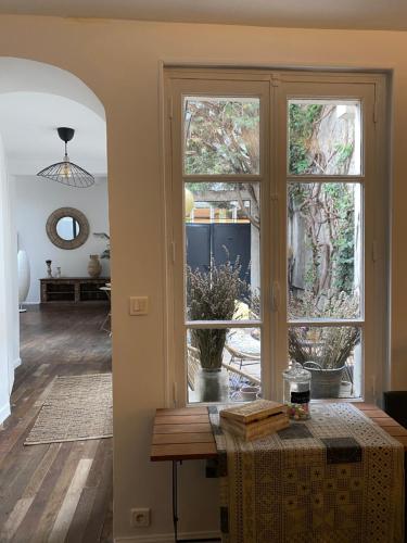 巴黎Artist's Home - Villa & Private Courtyard - 200m2的客厅设有桌子和大窗户