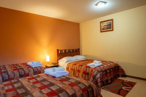 查查波亚斯Posada del Arriero -Hotel的两张位于酒店客房的床,配有毛巾