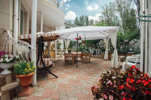 敖德萨Vilari Odessa的庭院配有白色遮阳伞和桌椅。