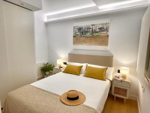 圣塞瓦斯蒂安APARTAMENTO MENTURA Centro de San Sebastian Parking FREE的一间卧室,配有一张床,上面有帽子