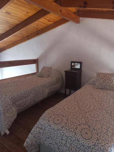 VillarsLa Yuma en Villars的一间卧室设有两张床和一张桌子及窗户