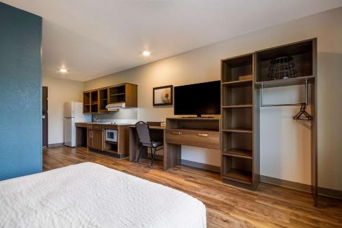 巴拿马城海滩WoodSpring Suites Panama City Beach的客房设有一张床、一张书桌和电视