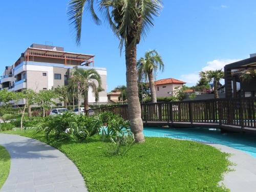弗洛里亚诺波利斯Apartamento Garden em condomínio clube的游泳池旁的棕榈树