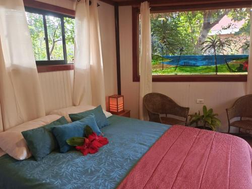 安加罗阿Cabañas Hua'ai Village的一间卧室,床上有红花