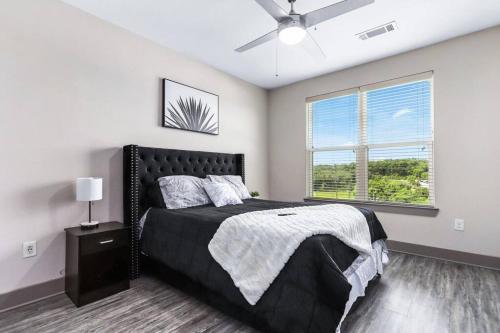 亚特兰大Luxury Buckhead Apartment的一间卧室设有一张黑色的床和一个窗户。