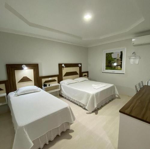 ParanavaíGrande Hotel的酒店客房设有两张床和柜台。