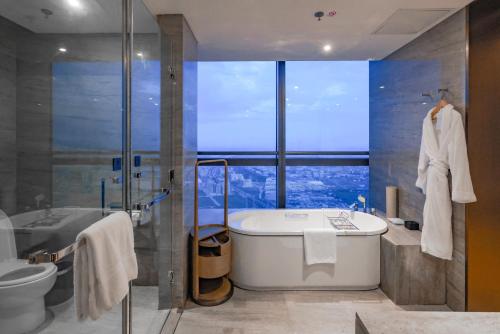 中山中山利和威斯汀酒店的一间带浴缸和淋浴的浴室,并设有一个窗户