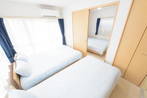 广岛COCOSTAY Felice ココステイ フェリーチェ的小房间设有床和镜子
