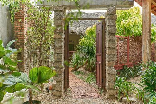 An Bàn (2)Pao Homes - An Bang Beach Stone Villa的花园入口,设有开放式门