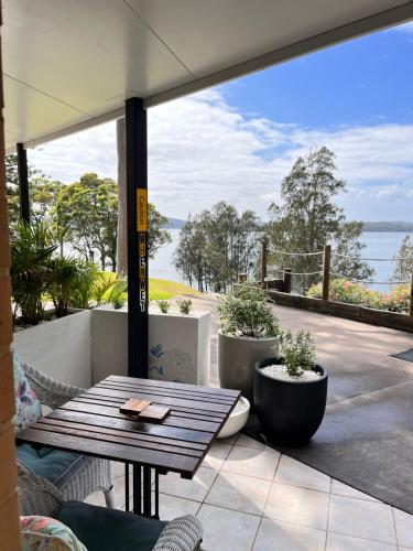 Morisset EastSilverWaters Waterfront Accommodation的一个带桌子并享有水景的庭院